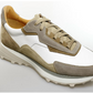 The Magnanni Onyx Sneaker showcases beige, white, and tan suede and leather panels, a chunky sole, beige laces, and a luxury design—displayed on a clean white background.