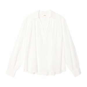 The Elena Top by Xirena is a loose-fitting, long-sleeve white popover with a Johnny collar and V-neck, made from lightweight cotton poplin, shown against a plain white background.
