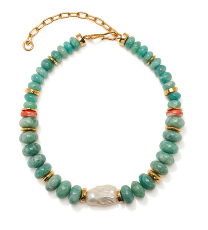 The Provence Necklace by Lizzie Fortunato features beaded green stones reminiscent of an amazonite collar necklace, accented with gold spacer beads, coral-colored details, a large central baroque pearl, and finished with a gold adjustable clasp.