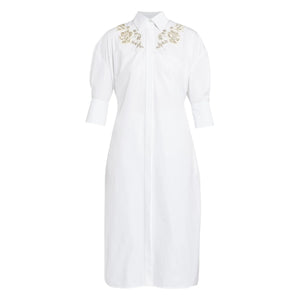 The Crystal Flower Embellished Shirt Dress by Erdem is a white cotton poplin, knee-length dress with three-quarter sleeves, floral crystal detailing on the shoulders, and a stylish tie-fastening belt.