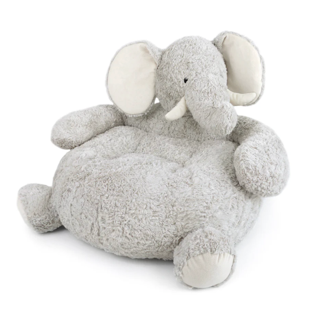 The Mon Ami Elephant Sofa is a plush chair shaped like a gray elephant, featuring round ears, a large trunk, and two white tusks—specially designed to provide children with cozy and comfortable seating.