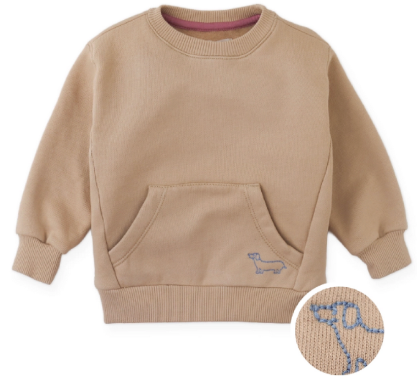 The Gingersnaps Baby Boys’ Ennio Pullover is a tan fleece sweatshirt for children, featuring a front embroidered pocket with a blue embroidered outline of a dachshund dog, shown in close-up detail.