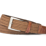 The Men's Solid Stretch Belt with Croc Tabs by W. Kleinberg is a braided brown belt with leather accents, a silver buckle, and genuine crocodile tabs, coiled neatly.
