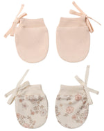 The Quincy Mae No Scratch Mittens, Set of 2, are shown in two designs—one pair in solid light pink and the other in cream with a floral pattern—each featuring a delicate side ribbon that pairs beautifully with a lightweight or cotton gauze bib for ultimate comfort and style.