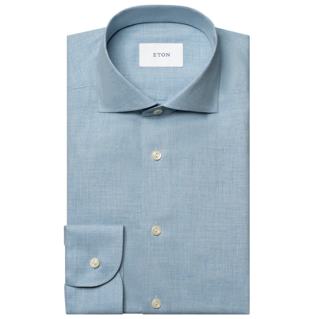 The Eton Slim Wide Spread Solid Signature Flannel Shirt, in light blue cotton with white buttons and a spread collar, is neatly folded and displayed on a white background—ideal for stylish cold-weather wear.