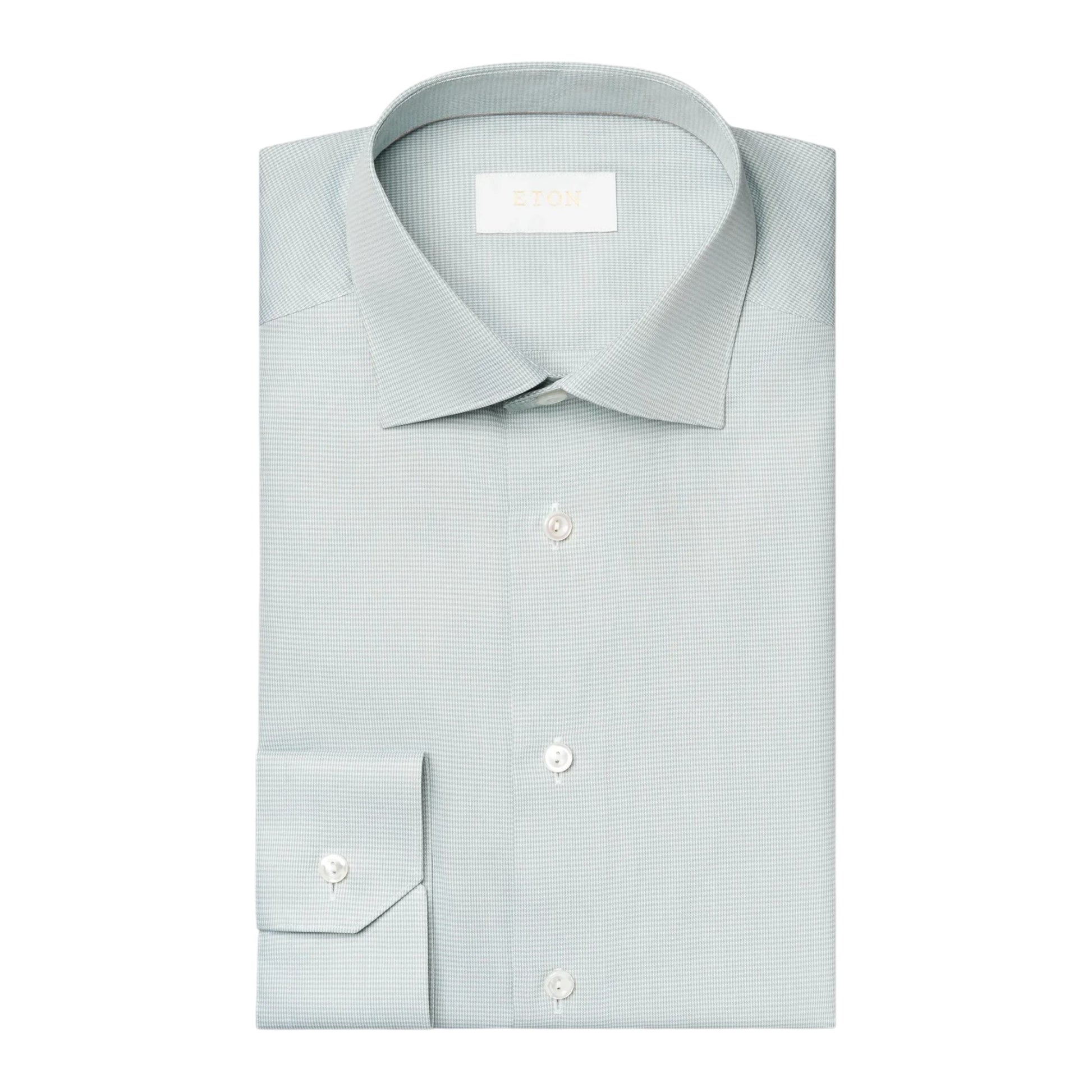 The Eton Mid Green Houndstooth Elevated Twill Shirt features a classic collar and white buttons, crafted from organic Supima cotton, and is displayed neatly folded against a plain white background.
