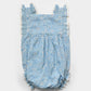 The Early Sunday Baby Girls’ Eva Baby Romper features a blue floral print with lace trim, ruffled shoulder details, and button closures on the back, shown against a white background. This essential piece combines charming style and everyday comfort for your little one.