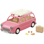 A Calico Critters Family Picnic Van in pink, featuring a white roof rack and including picnic accessories such as a suitcase, two cups, three croissants, and pieces of butter—ideal for imaginative playtime adventures.