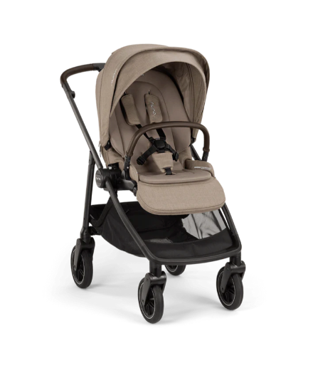 The Nuna SWIV Stroller is a modern beige stroller with a black frame, four 360-degree swivel wheels, a safety harness, detachable bumper bar, and storage basket—designed for the spontaneity of parenthood.