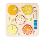 A Tender Leaf Toys wooden cutting board with Tenderleaf Citrus Fractions fruit slices and a knife, perfect for teaching fractions.