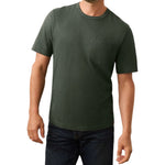 A man models the Faherty Sunwashed Pocket Tee in dark green with short sleeves and a chest pocket, paired with dark blue jeans, set against a white background to highlight its relaxed silhouette.