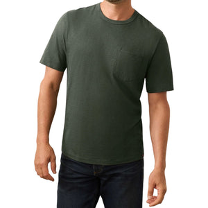 A man models the Faherty Sunwashed Pocket Tee in dark green with short sleeves and a chest pocket, paired with dark blue jeans, set against a white background to highlight its relaxed silhouette.