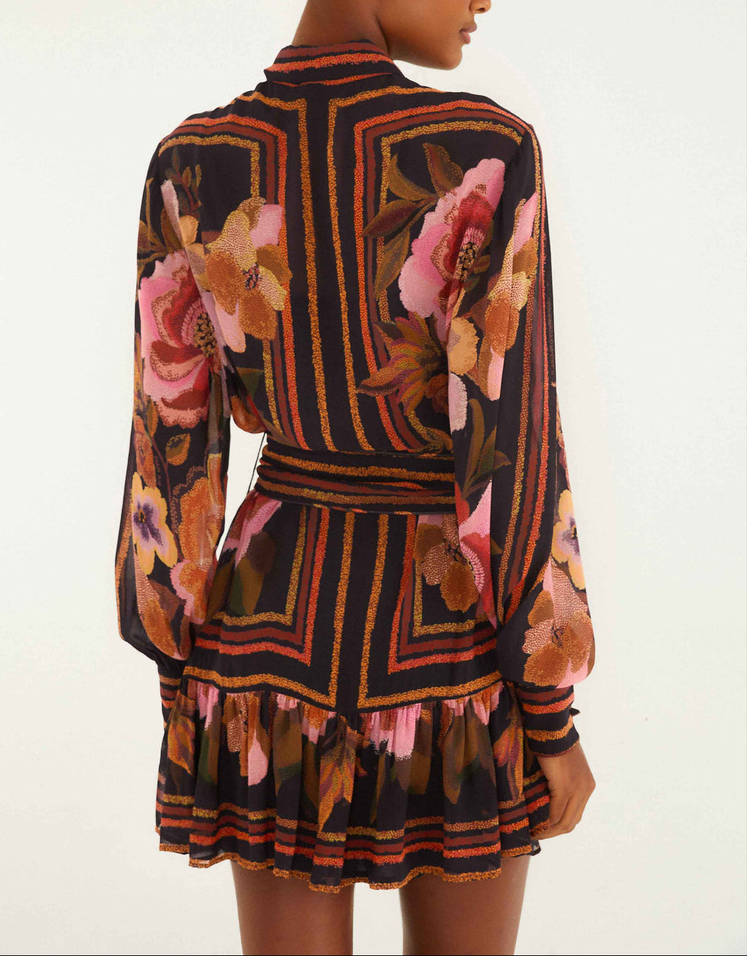 A person is shown from the back wearing the Farm Rio Chenille Flowers Black Mini Dress, featuring long sleeves, colorful floral patterns, and a ruffled skirt.