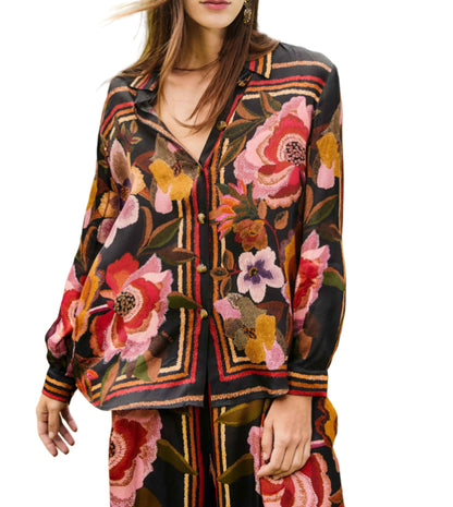 A woman wears the Farm Rio FR Chenille Flowers Black Shirt, a dark long-sleeved top with bold florals and geometric stripes, made from eco-conscious viscose and paired with matching pants.