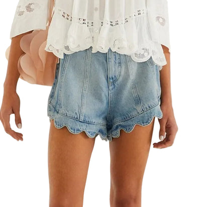 A person wearing a white long-sleeve blouse with lace trim and Farm Rio's Light Denim Romantic Wavy Hem Shorts.