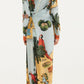 A woman is seen from the back wearing the Farm Rio Beaches Path Multicolor Maxi Dress, a long-sleeved, ankle-length dress featuring a vibrant tropical print.