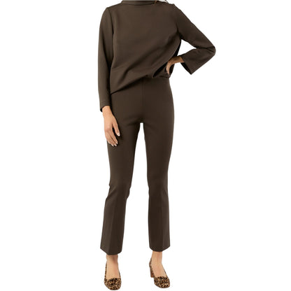 A person wears Ann Mashburn's Faye Flare Cropped Pant with a brown long-sleeve top and leopard print shoes, standing with one hand on their hip against a white background.
