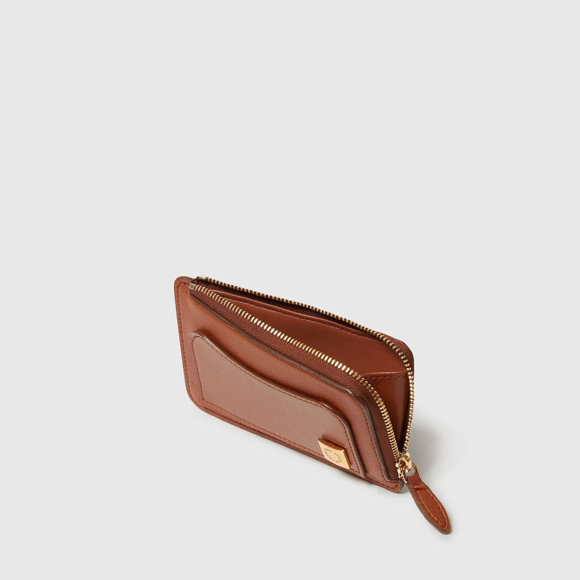 The Stella McCartney Ryder Zipper Cardholder is an animal leather alternative in brown, featuring a gold zipper and exterior pocket, shown on a plain light background.