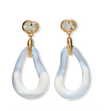 The Galina Earrings by Lizzie Fortunato feature gold-tone studs with clear gemstones and twisted, translucent blue and white resin teardrop hoops.