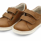 The Boys' Kyle Double Strap Sneaker by L'Amour Shoes features a brown design, white soles, two hook-and-loop straps per shoe, and a cushioned memory foam leather sockbed for all-day comfort.