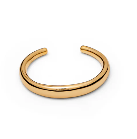 The Amanda Bracelet by Lie Studio features a plain, polished gold design with a slightly thick, rounded band and open back, photographed on a white background. This elegant accessory adds effortless style and sophistication.