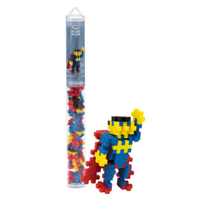 A Plus Plus Tube - Superhero stands behind a blue, yellow, and red superhero figure with cape and raised arm, encouraging creative play and developing fine motor skills.