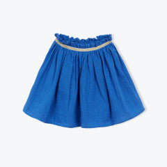 The Girls' Fotini Skirt by Arsene & Les Pipelettes is a blue, knee-length flared skirt with a ruffled elastic waistband and thin gold trim near the top, shown against a plain background.