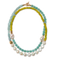 The Cabana Necklace by Lizzie Fortunato features green, blue, and turquoise beads with large white pearls and a gold clasp in a striking double strand design.