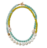 The Cabana Necklace by Lizzie Fortunato features green, blue, and turquoise beads with large white pearls and a gold clasp in a striking double strand design.