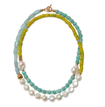 The Cabana Necklace by Lizzie Fortunato features green, blue, and turquoise beads with large white pearls and a gold clasp in a striking double strand design.