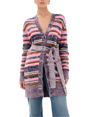 A woman wears the Figue Erica Cardigan Sweater, a heavyweight soft knit with pink, brown, and purple stripes, styled over blue jeans.
