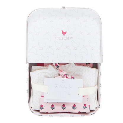 The Pink Chicken Nesting Box Baby Take Home Set features folded pink and white organic pima cotton newborn clothing in a white gift box with a chicken pattern and includes "The Welcoming Box" card—perfect for bringing baby home in comfort and style.