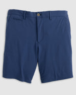 The Jupiters Short by Johnnie-O is a pair of blue men's golf shorts made from technical performance cotton, with a button closure, belt loops, front pockets, and a single welt pocket on the right side.