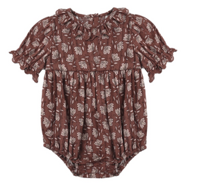 The Rylee & Cru Baby Girls’ Liv Romper features short ruffled sleeves, a ruffled collar, and an all-over white floral print on a brown background for a sweet vintage-inspired look.