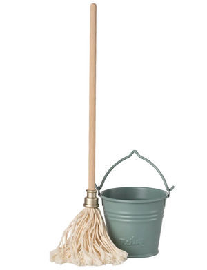 A wooden mop with a sturdy handle stands next to the Maileg Light Blue Bucket and Mop - Miniature, creating a charming cleaning set.