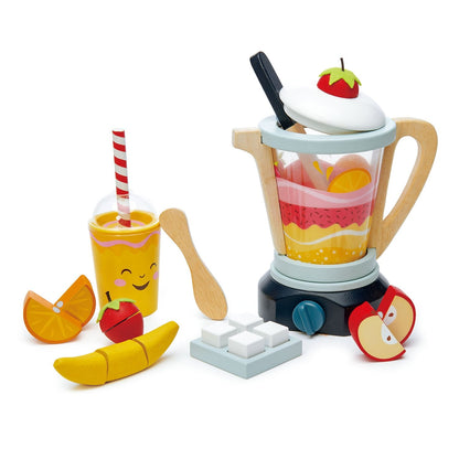 Colorful toy kitchen set featuring a Tender Leaf Toys Tenderleaf Fruity Blender, various fruit pieces you can cut, a drink with a straw, and a wooden spoon on a white background.