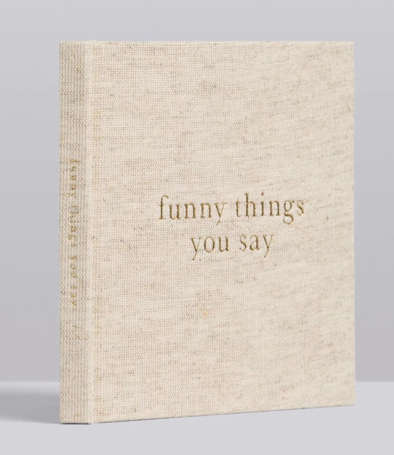 A Write To Me Funny Things You Say Oatmeal small beige hardcover journal titled "funny things you say" with a textured cloth cover and gold text, perfect for capturing memorable quotes from kids.