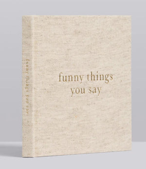 A Write To Me Funny Things You Say Oatmeal small beige hardcover journal titled "funny things you say" with a textured cloth cover and gold text, perfect for capturing memorable quotes from kids.