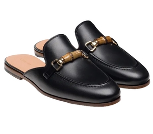 The Magnanni Sienna Luck II Mule is a black leather slip-on loafer featuring brown bamboo and metal horsebit accents across the top.