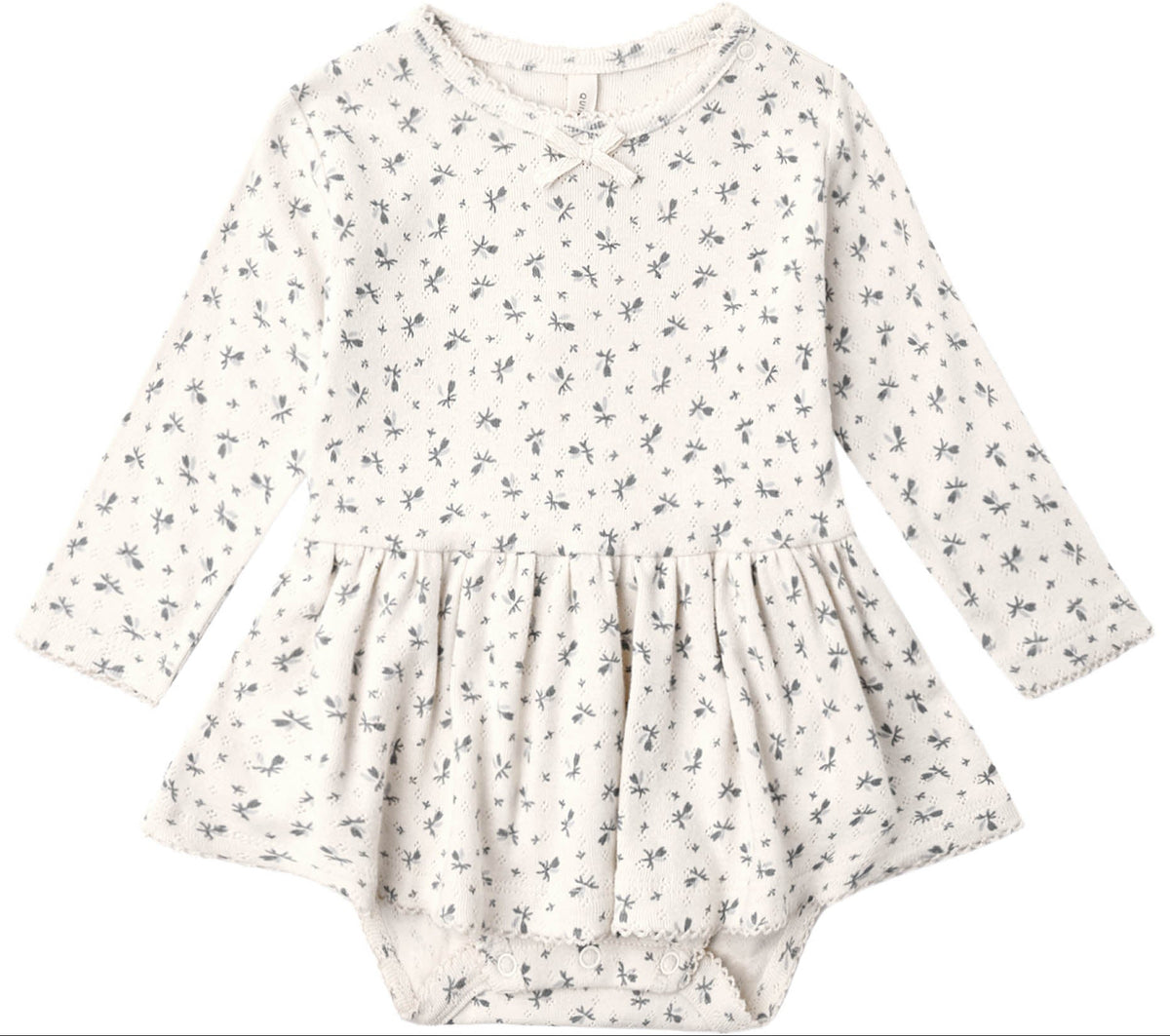 Introducing the Quincy Mae Baby Girls’ Pointelle Skirted Bodysuit—an off-white long-sleeve dress adorned with a delicate dark floral pattern. Featuring a gathered peplum skirt and practical snap closures at the bottom, this bodysuit blends comfort and charm in Quincy Mae’s signature style for little ones.