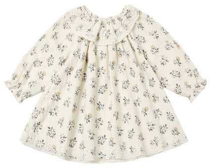 The Baby Girls’ and Girls’ Long Sleeve Isla Dress by Quincy Mae features a cream background with a delicate yellow and gray floral print, ruffled neckline, and lace-trimmed collar and hem. Expertly crafted from woven cotton, this dress offers timeless style and comfort.