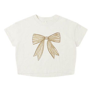 Rylee & Cru’s Baby Girls' and Girls' Boxy Tee features a white short-sleeve design with a large gold ribbon bow graphic on the front and a classic crew neckline for a relaxed, boxy fit.