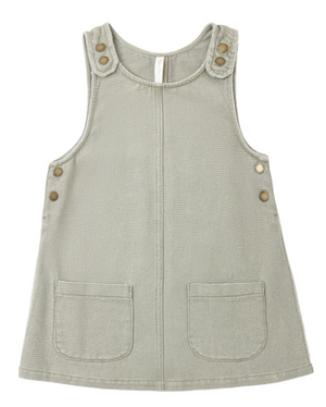Girls’ Odette Overall Dress by Rylee & Cru in light gray, a sleeveless denim piece for toddlers with two front pockets and six metallic buttons on the shoulders and sides, shown laid flat on a white background.