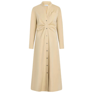 The Genny Dress by Callas Milano is a beige, long-sleeve button-front dress in Italian shirting twill with a fit-and-flare silhouette, gathered knot waist detail, and chest pocket, shown on a plain white background.
