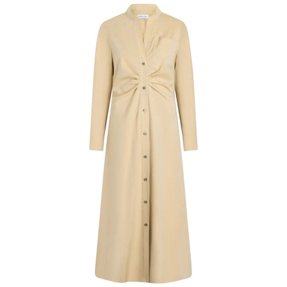 The Genny Dress by Callas Milano is a beige, long-sleeve button-front dress in Italian shirting twill with a fit-and-flare silhouette, gathered knot waist detail, and chest pocket, shown on a plain white background.