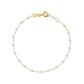 The Classic Gigi Bracelet 6.7" by Gigi Clozeau is a stunning 18 carat yellow gold piece, featuring small light blue beads and a simple clasp mechanism.