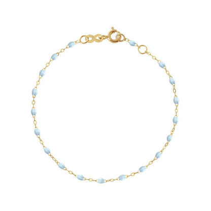 A delicate Gigi Clozeau Classic Gigi bracelet in 18 carat Yellow Gold with light blue, oval-shaped beads connected by small golden links, displayed against a white background with the text "baby blue" underneath. Ideal