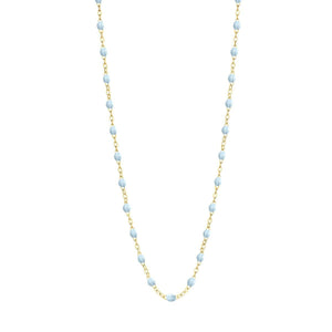 The Gigi Clozeau Classic Gigi Necklace 19.7" showcases striking jewels with a gold chain highlighted by meticulously spaced light blue beads, crafted from 18-carat yellow gold.