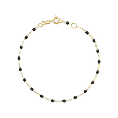 A Gigi Clozeau Classic Gigi Bracelet in 18 carat Yellow Gold and black bead necklace isolated on a white background with the word "black" indicating the bead color.