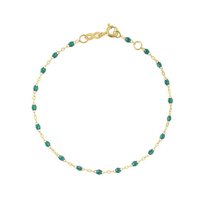 A Gigi Clozeau Classic Gigi bracelet in 18 carat Yellow Gold with emerald gemstones, displayed against a white background with the word "emerald" beneath it.